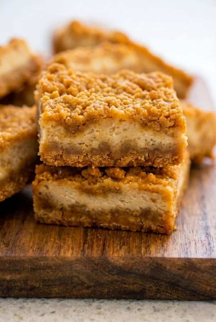 Overhead shot of butterscotch graham cracker cheesecake bars cut into squares in a baking pan.