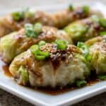 Cabbage dumplings filled with chicken and vegetables, served with soy sauce and chili oil.