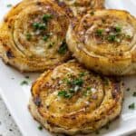 Crispy golden puff pastry pinwheels garnished with herbs, shown as a savory side dish.