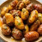 Golden honey mustard baby potatoes garnished with chives, served as an easy skillet side dish.