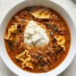 Lasagna soup with bowtie pasta, ground beef, and a creamy ricotta topping.