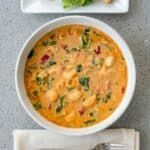 Overhead view of creamy Marry Me Chicken Soup with pasta and spinach in a bowl.