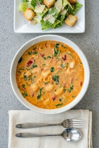 Marry Me Chicken Soup – Rich, Creamy & Packed with Bold Italian Flavor Overhead view of creamy Marry Me Chicken Soup with pasta and spinach in a bowl.