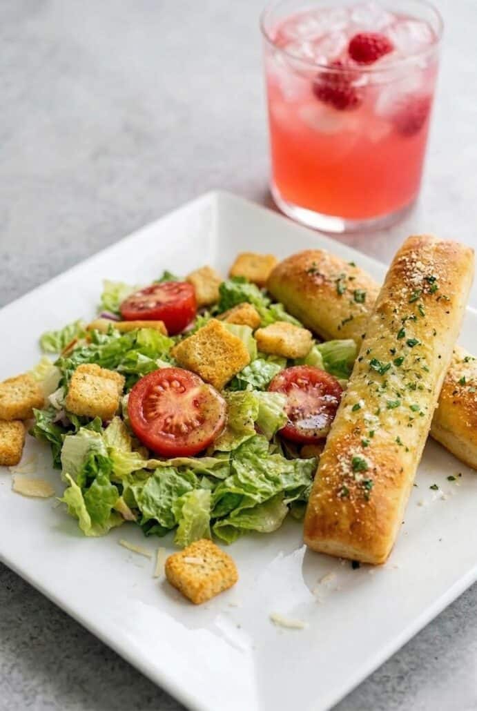 Olive Garden-style salad, featuring crisp lettuce, tomatoes, croutons, and zesty dressing.