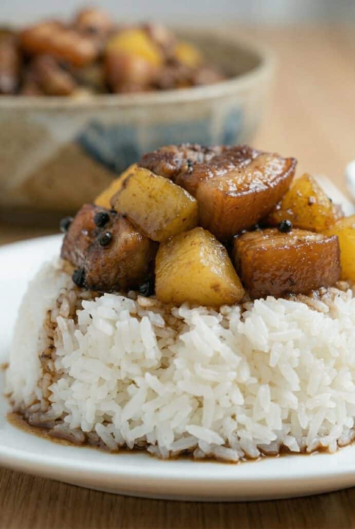 Close-up of Pork Hamonado over white rice, showing tender pork belly and pineapple in a glossy sweet savory sauce.