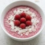 Raspberry chia pudding topped with fresh raspberries and coconut flakes, a healthy vegan breakfast.