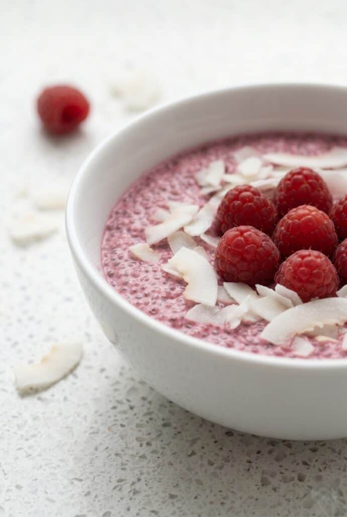 Raspberry chia pudding topped with fresh raspberries and coconut flakes, a creamy healthy breakfast ready to enjoy.
