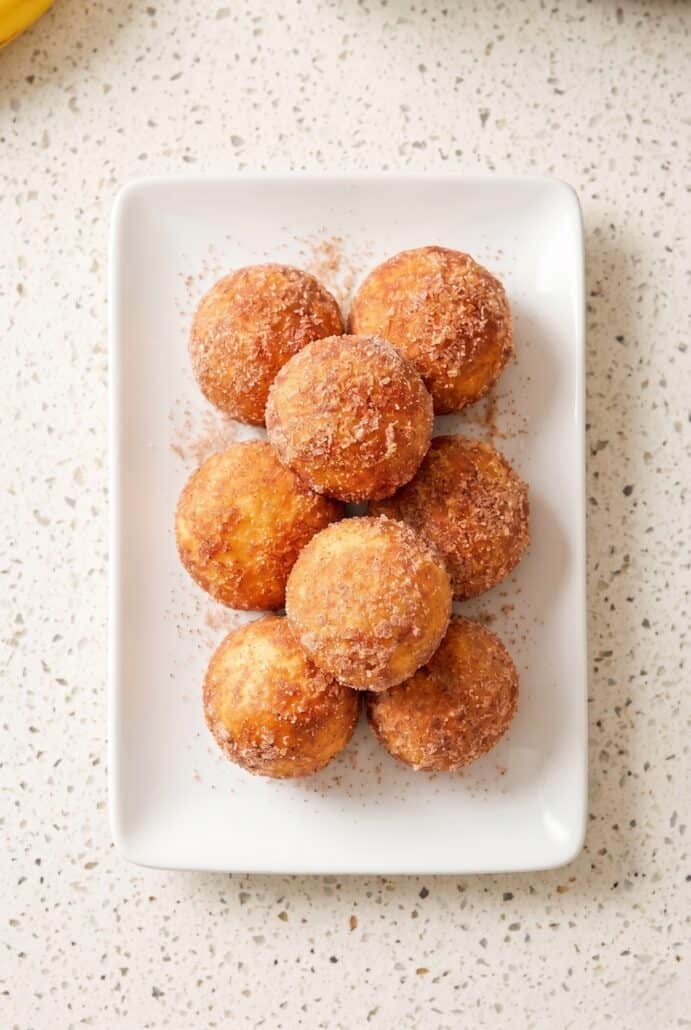 Cinnamon sugar air fryer banana donut holes served warm on a platter.