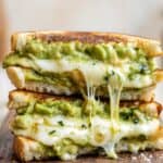 Avocado grilled cheese sandwich with melted cheese and creamy avocado filling.