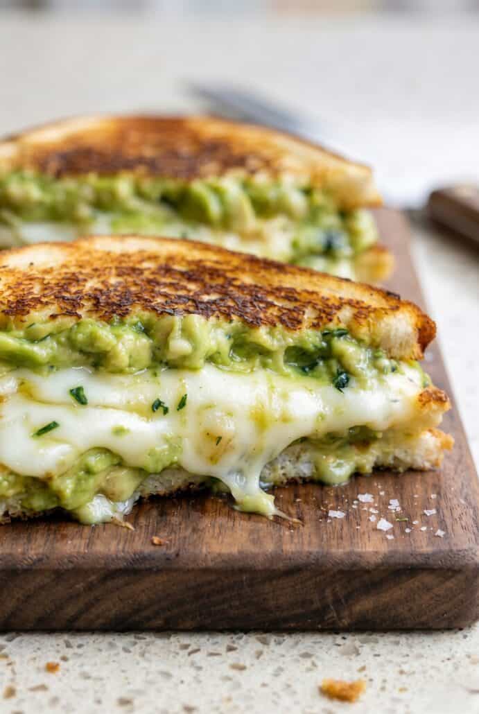 Close-up of avocado grilled cheese with crispy golden bread and melted cheese.