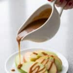 Caramel sauce drizzled over apple slices for a sweet dessert topping.