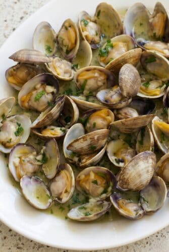 Garlic Butter Sauteed Clams Recipe Close-up of garlic butter sauteed clams with parsley in a flavorful white wine sauce.