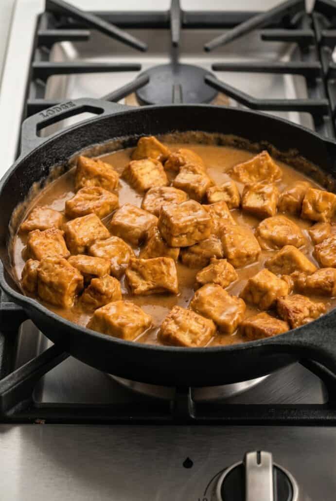 Garlic pork bites simmering in a creamy sauce in a skillet for an easy stovetop pork dinner.