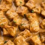 Close-up of creamy garlic pork bites with parsley for a rich and easy skillet pork dinner.