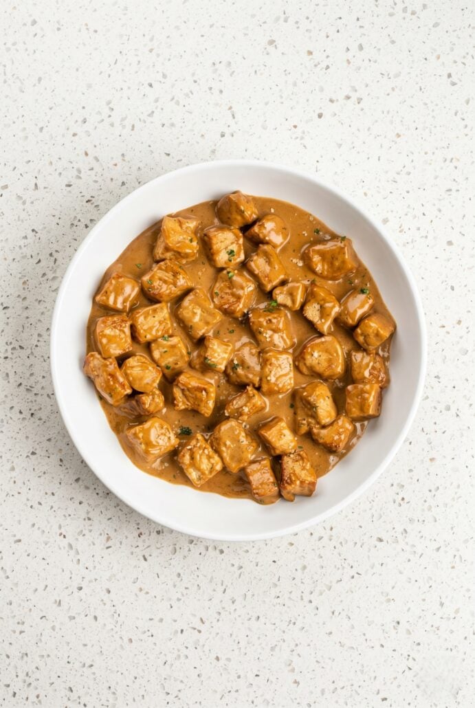 Creamy garlic pork bites served in a white bowl for an easy pork dinner.