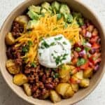Loaded Potato Taco Bowl with crispy roasted potatoes, seasoned beef, avocado, pico de gallo, cheese, and sour cream.