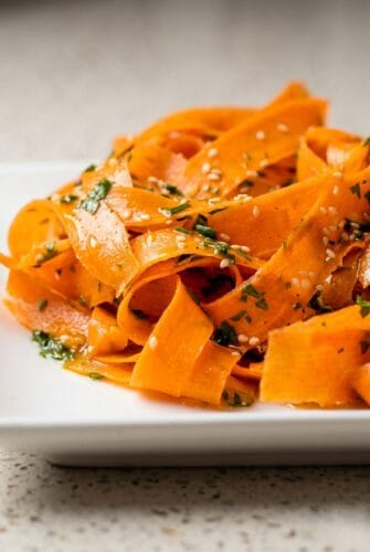 Best Raw Carrot Salad Recipe (Easy & Crunchy) Raw carrot salad with thin carrot ribbons, herbs, and sesame seeds.