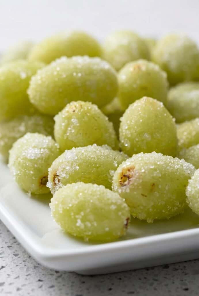 Frozen Sour Patch Grapes coated in sugar for a sweet and tangy snack.