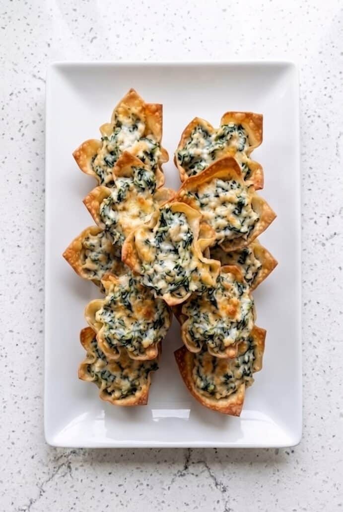 Spinach artichoke wonton cups served on a platter as an easy crispy party appetizer.