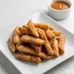 Air fryer apple fries served with caramel sauce for dipping.
