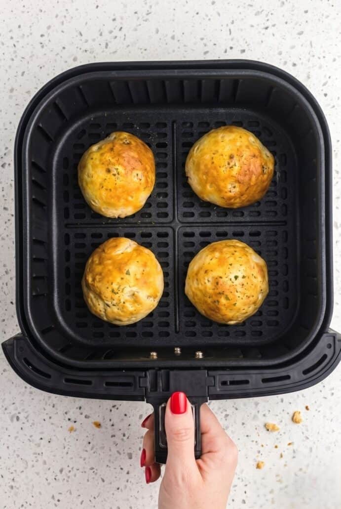 Cooked air fryer taco bombs in the basket, golden brown and ready to serve.