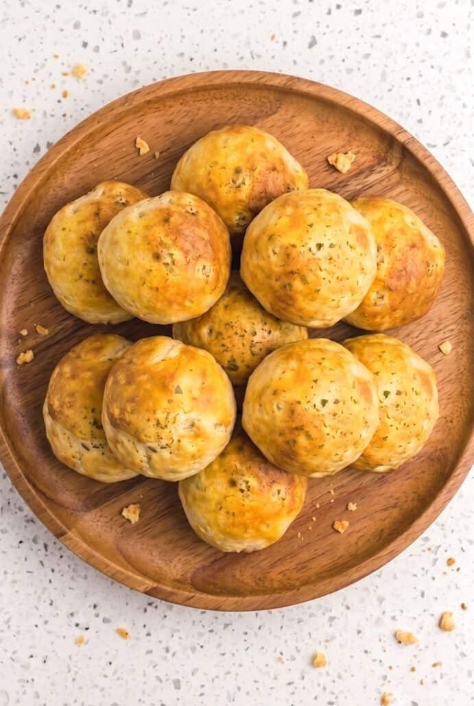 Golden air fryer taco bombs on a wooden plate, ready for an easy cheesy taco appetizer.