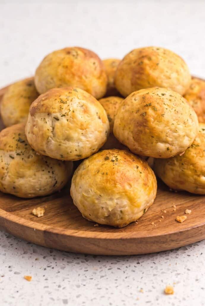 Golden air fryer taco bombs on a wooden plate, perfect for an easy cheesy taco appetizer.