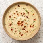 Creamy baked potato soup topped with crispy bacon, chives, and cheddar cheese.