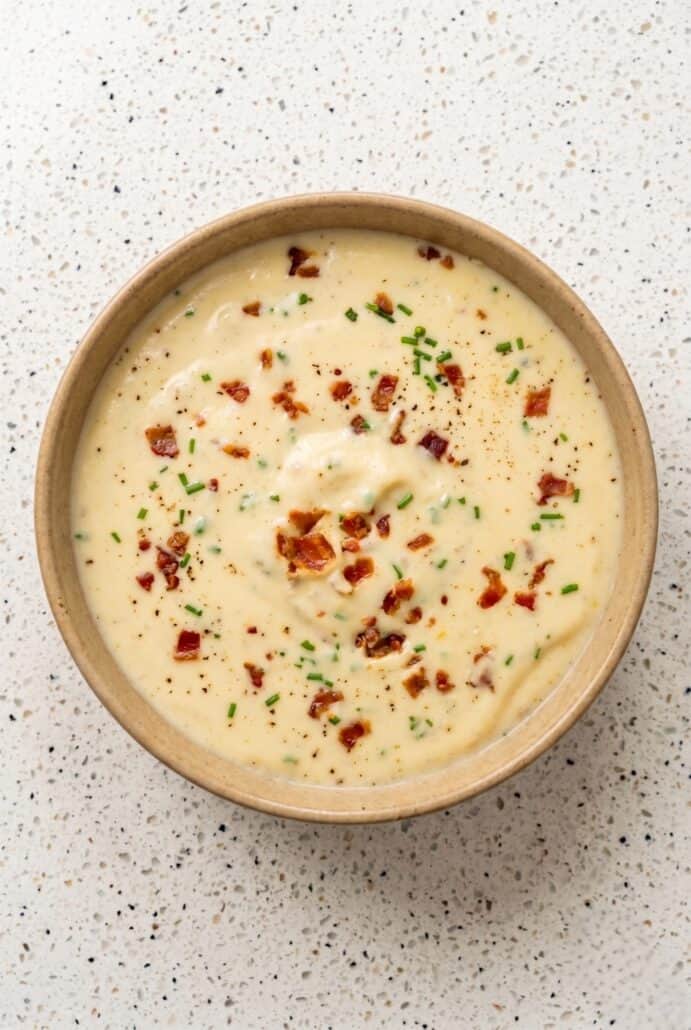 Creamy baked potato soup topped with crispy bacon, chives, and cheddar cheese.