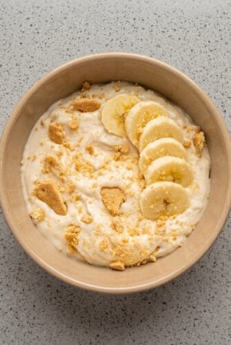 Easy Banana Pudding Yogurt - 5 Minute Recipe Creamy Banana Pudding Yogurt bowl topped with fresh banana slices and graham cracker crumbs.