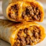 Beef and cheese chimichangas cut open showing crispy tortilla and seasoned ground beef filling.