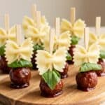 Bowtie pasta and cocktail meatball skewers with basil for easy party appetizer.