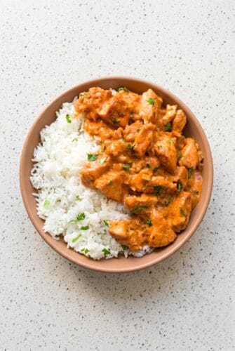 Coconut Chicken Rice Bowl Recipe (A Tropical Weeknight Dinner!) Coconut chicken rice bowl with creamy sauce served over white rice and fresh cilantro.