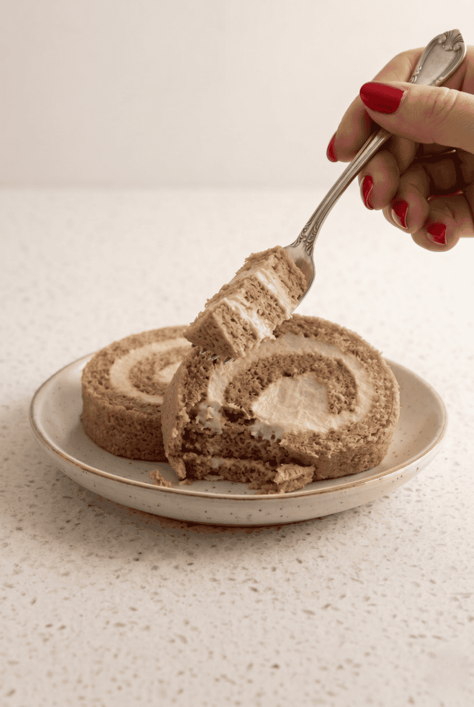 Serving a slice of Coffee Swiss Roll with fluffy espresso cream filling.