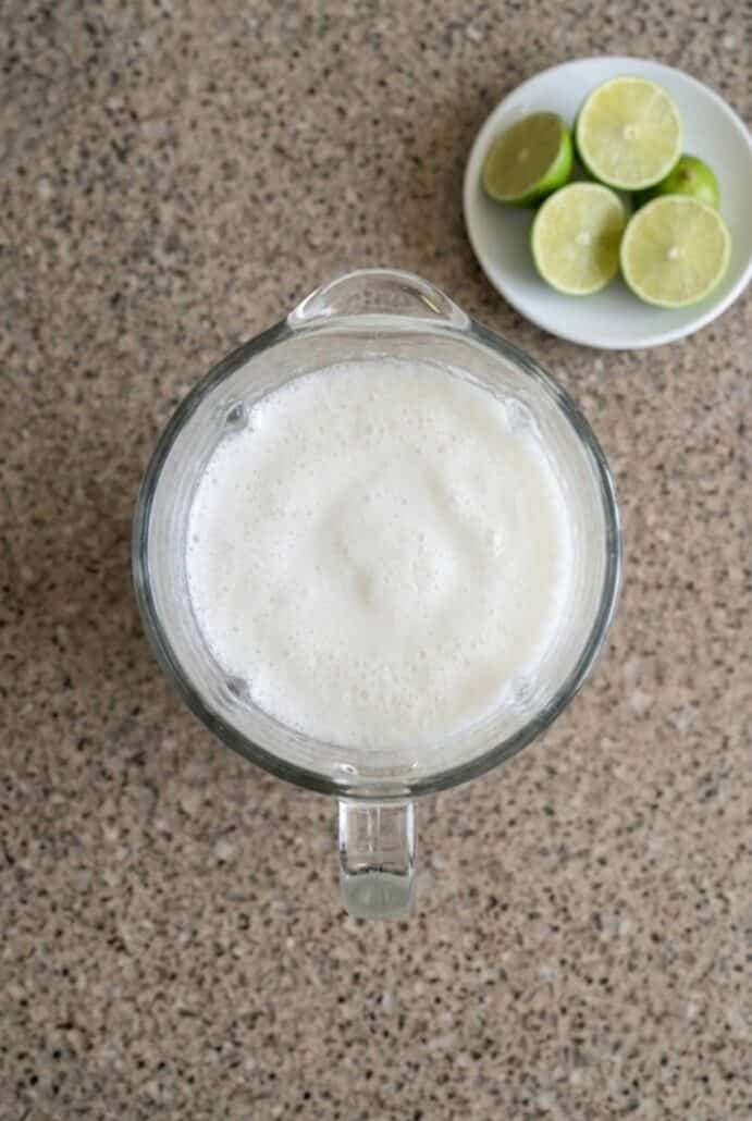Blender filled with creamy Colombian coconut limeade for Limonada de Coco recipe.