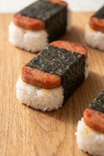 Hawaiian Spam Musubi Recipe (Sticky, Savory & Better Than Takeout!) Hawaiian Spam musubi with caramelized Spam, sushi rice, and nori wrap on a wooden board.