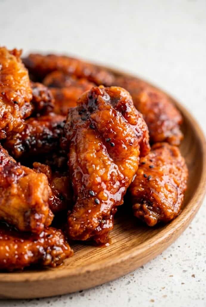 Close-up of crispy Hot Honey Peach Wings coated in a sticky peach glaze, showcasing the sweet and spicy sauce.