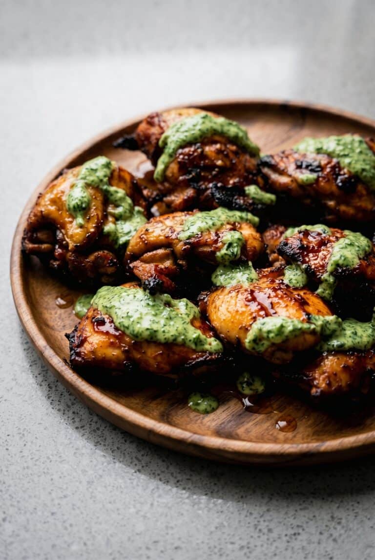 Grilled Peruvian chicken with creamy green sauce on a plate.