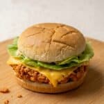 Spicy fried chicken burger with cheese, lettuce, and spicy mayo on a toasted bun.