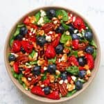 Strawberry spinach salad with blueberries, feta, pecans, and balsamic glaze for an easy summer side dish.