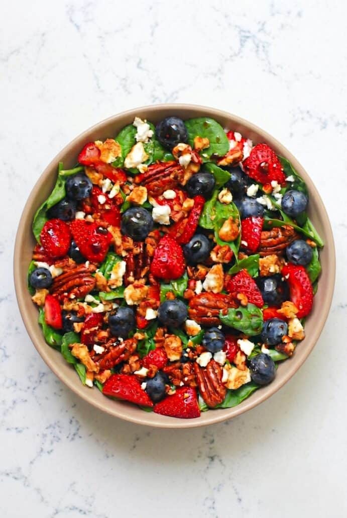 Strawberry spinach salad with blueberries, feta, pecans, and balsamic glaze for an easy summer side dish.