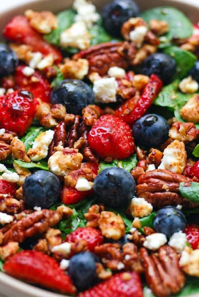 Close-up of strawberry spinach salad with blueberries, feta, and pecans for a fresh summer side dish.