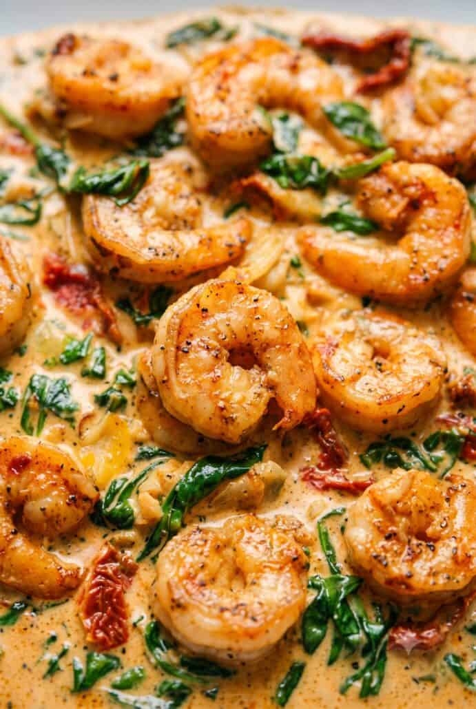 Creamy Tuscan shrimp close-up with spinach, artichokes, and sun-dried tomatoes.