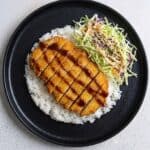 Chicken Katsu served over rice with colorful cabbage slaw and tonkatsu sauce.
