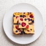 Four berry baked yogurt squares served on a white plate for breakfast or a snack.