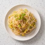Korean bean sprout salad with sesame seasoning served in a white plate.