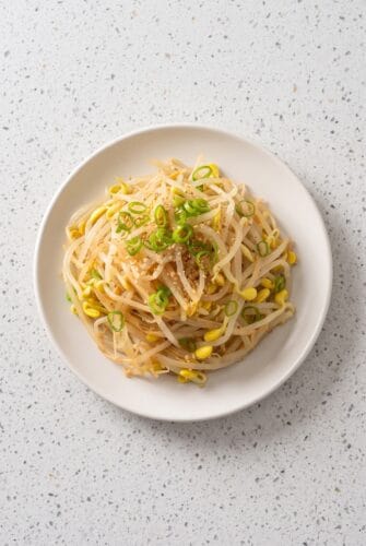 Korean Bean Sprout Salad (Light, Healthy Side Dish) Korean bean sprout salad with sesame seasoning served in a white plate.