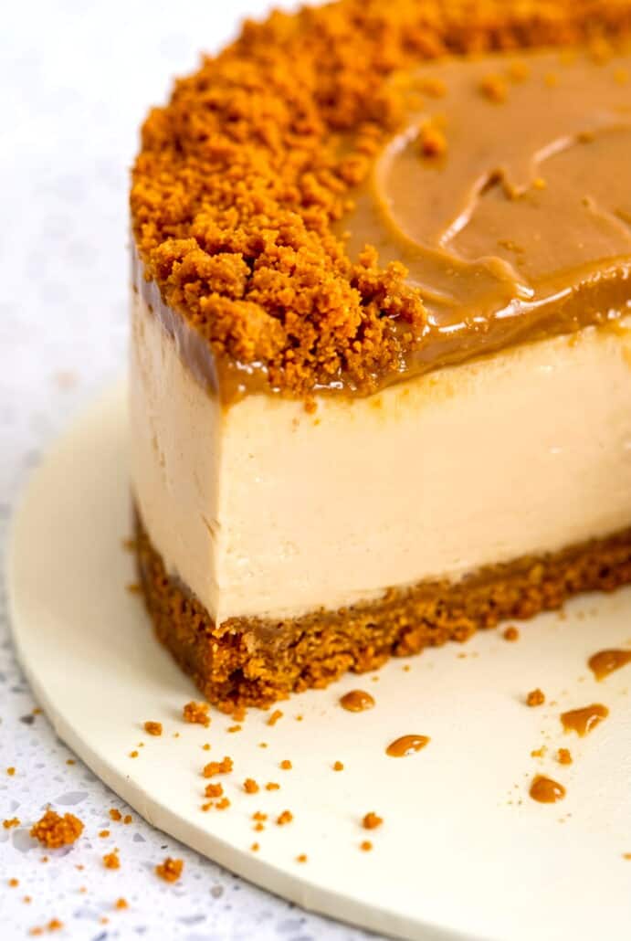 Close-up of sliced Biscoff cheesecake with creamy filling, cookie butter topping, and crushed biscuits.