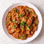 Carne guisada with tender beef in rich tomato gravy, topped with fresh cilantro.