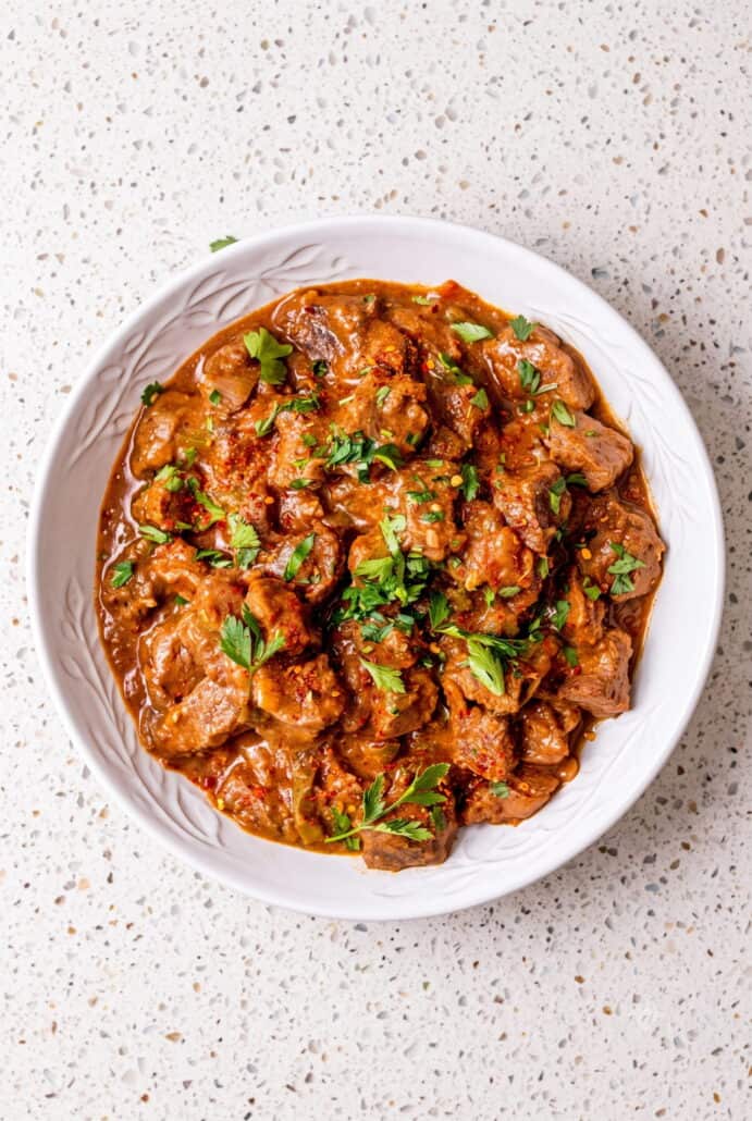 Carne guisada with tender beef in rich tomato gravy, topped with fresh cilantro.